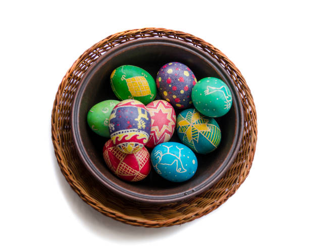 istock colorful painted Easter eggs in a woven straw basket isolated on white background 905878694
