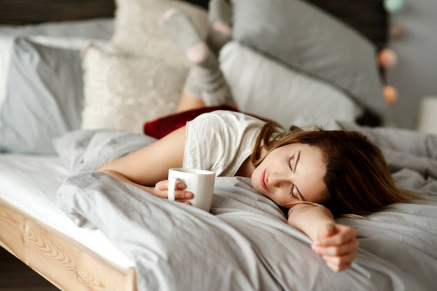 femme avec café couché dans son lit - être étendu sur le ventre photos et images de collection