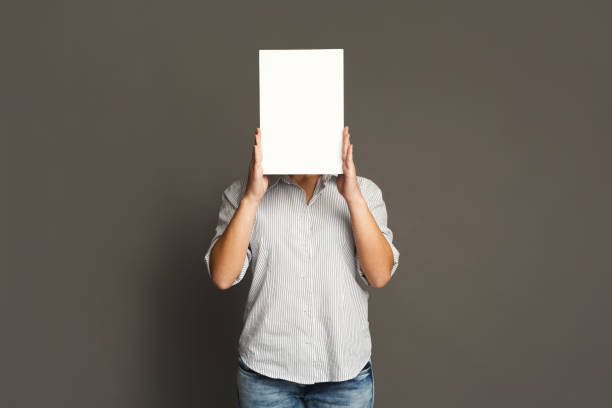 istock Young woman with blank white paper at face 905879730