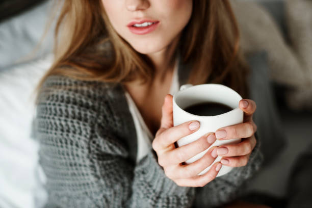 istock Unrecognizable woman with coffee mug on bed 905883064