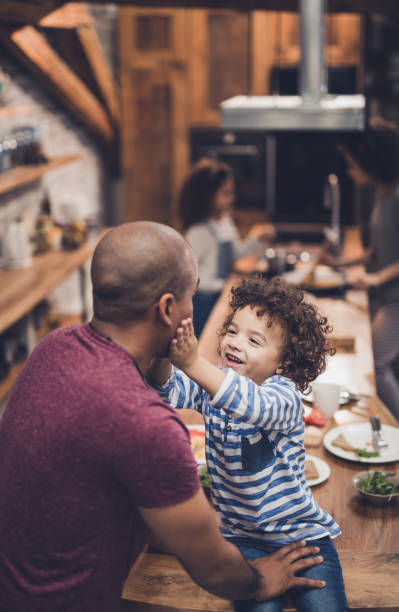 istock Cute black boy showing affection towards his father in the kitchen. 905883112