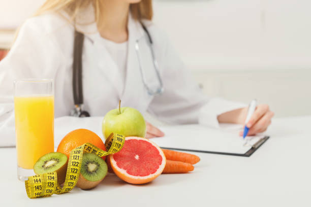 istock Nutritionist desk with fruit and measuring tape 905883230