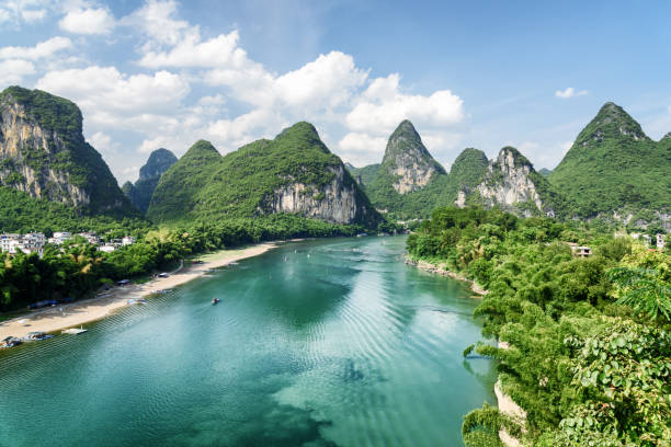 Wonderful summer sunny landscape at Yangshuo County of Guilin Wonderful summer sunny landscape at Yangshuo County of Guilin, China. Amazing view of karst mountains and the Li River (Lijiang River) with azure water. Beautiful green hills on blue sky background. li river stock pictures, royalty-free photos & images