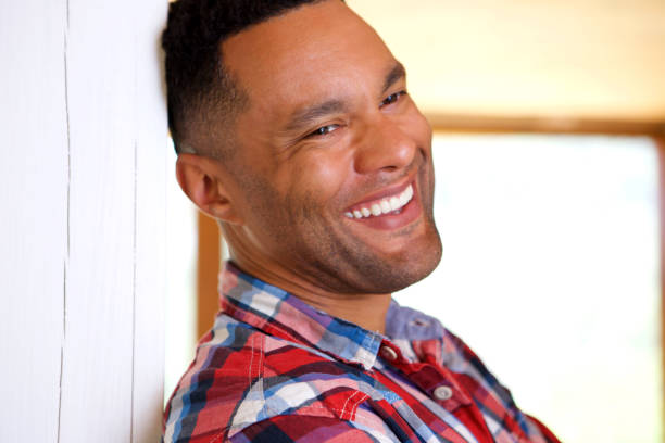 istock Close up black young man leaning against wall and laughing 905883598