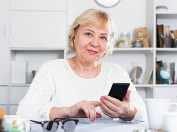 istock Mature woman with smartphone 905884196