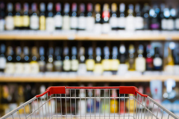Abstract blur wine bottles on liquor alcohol shelves in supermarket background Shopping cart view with Abstract blur wine bottles on liquor alcohol shelves in supermarket or wine store background liquor store counter photos stock pictures, royalty-free photos & images