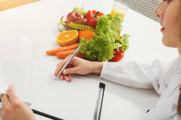 istock Nutritionist doctor writing diet plan on table 905885058