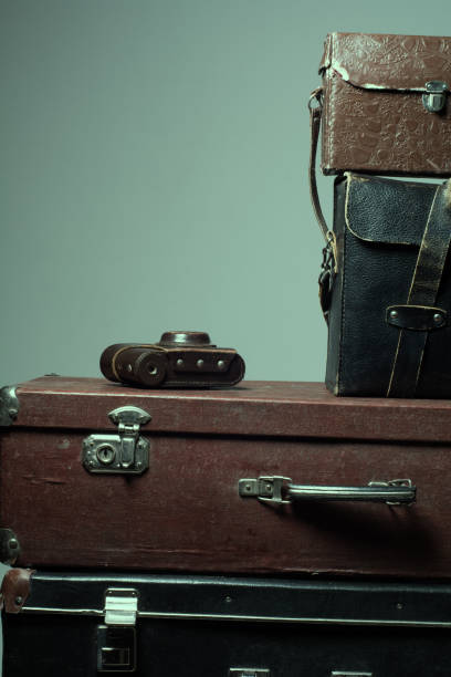 istock Background stack of old shabby suitcases and the camera 905890042