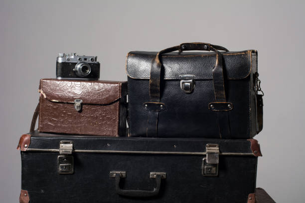 istock Stack of old shabby suitcases and camera 905890058