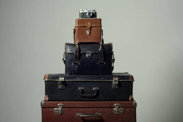 istock Stack of old shabby suitcases and camera 905890066