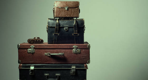 istock Background stack of old shabby suitcases and camera 905890364