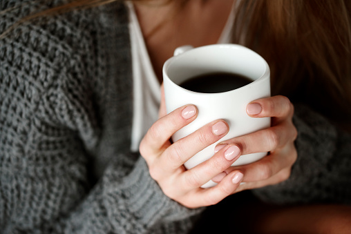 Human hand holding coffee mug