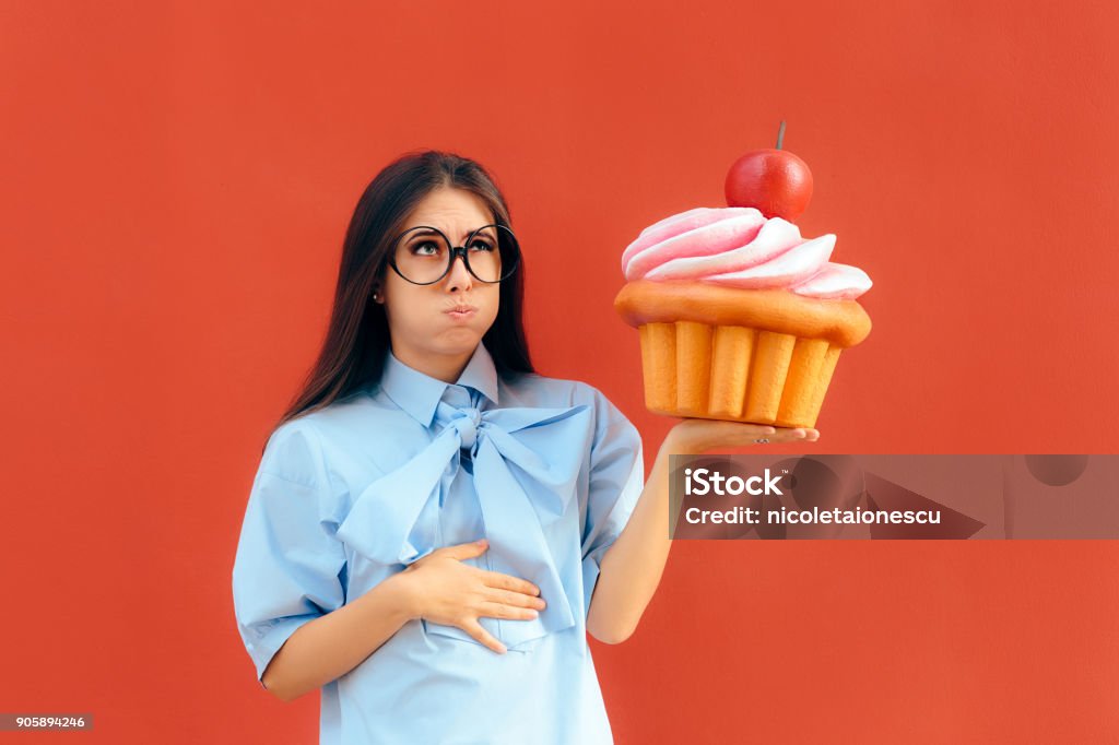 Frau leidet Magenschmerzen nach dem Essen zuviel Cupcake - Lizenzfrei Voll Stock-Foto