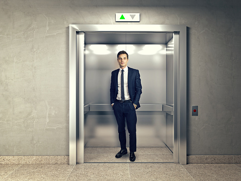 standing young businessman in modern elevator