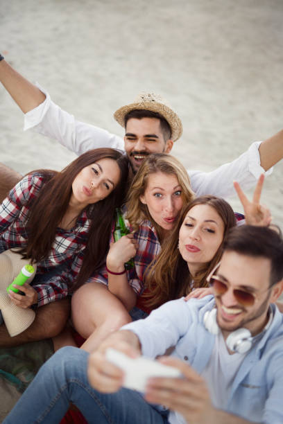 istock Group of cheerful friends having great time at beach 905897642