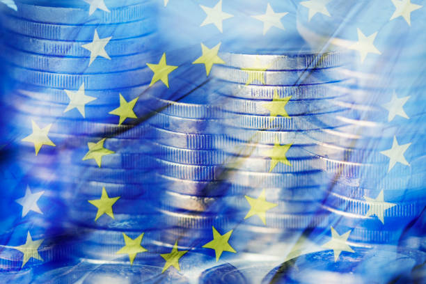 euro coins and the flag of the European Union a multiple exposure of some piles of euro coins and a flag of the European Union devaluation stock pictures, royalty-free photos & images