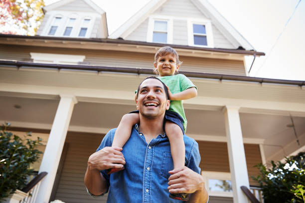 istock Father Giving Son Ride On Shoulders Outside House 905898930