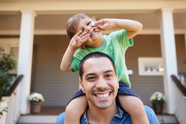 istock Father Giving Son Ride On Shoulders Outside House 905898932