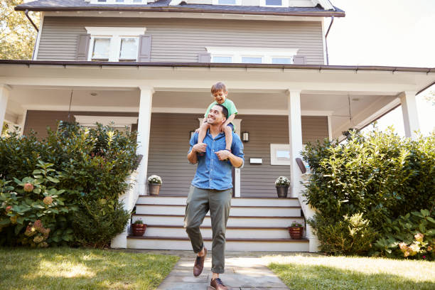 istock Father Giving Son Ride On Shoulders Outside House 905899030