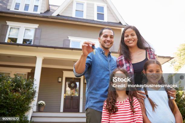 Portrait Of Family Holding Keys To New Home On Moving In Day Stock Photo - Download Image Now