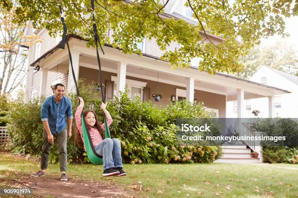 Father Pushing Daughter On Garden Swing At Home Stock Photo - Download Image Now - Family, Outdoors, Domestic Life