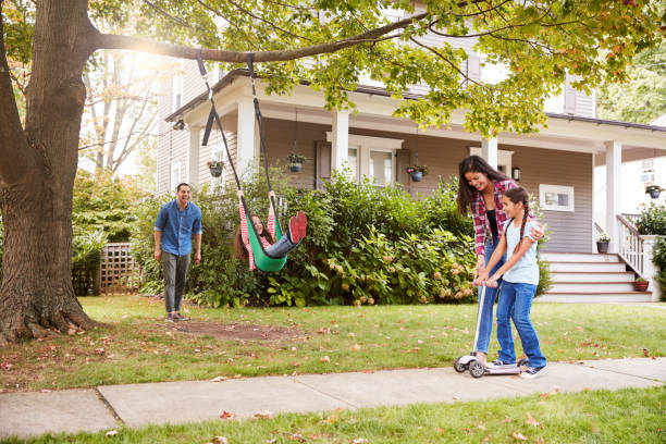 дети, играющие на качелях сада и скутере вне дома - child swing swinging playing стоковые фото и изображения