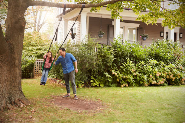 istock Father Pushing Daughter On Garden Swing At Home 905902244