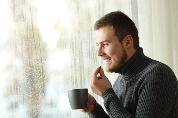 istock Happy man taking a pill in winter at home 905902834