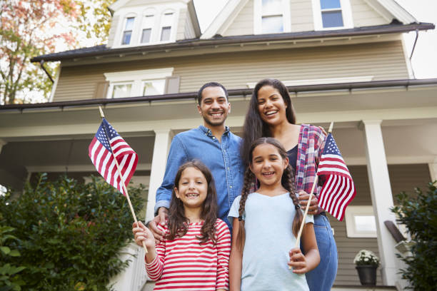 portrait de famille à l’extérieur de la maison, tenant des drapeaux américains - usa child flag the americas photos et images de collection