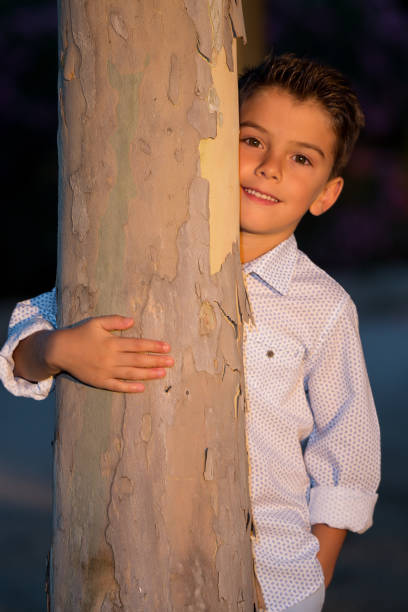 istock Adorable stylish kid embracing tree 905905460