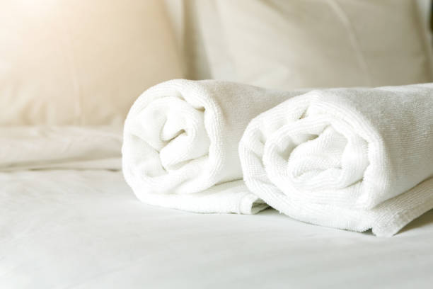 istock White towels on bed in hotel bedroom closeup 905906298