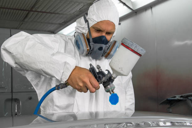 istock Painter with spray gun sprays the part on the car. 905908536