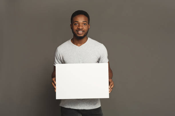 foto de joven afroamericano con pizarra en blanco - people holding one person sign fotografías e imágenes de stock