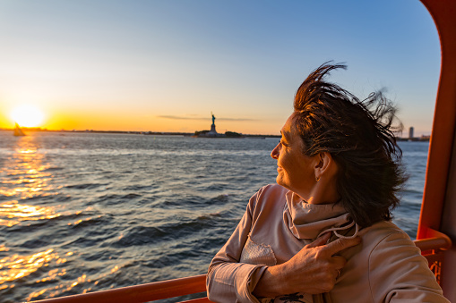 Smiling women on ferry near The Statue of Liberty - New York City