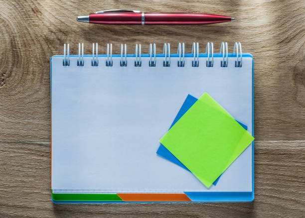 istock Reminder notes spiral notebook pen on wooden board 905913732