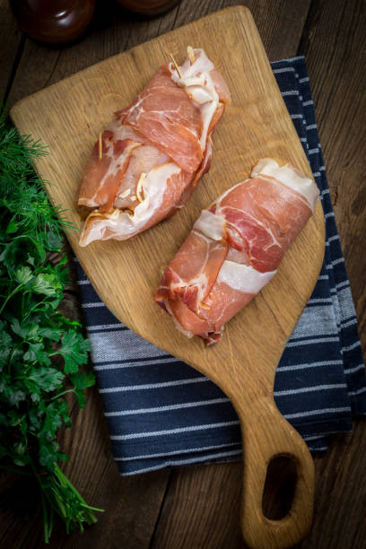 istock Raw chicken breast stuffed with champignon wrapped with bacon. 905914240