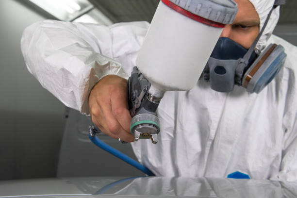istock Painter spray gun in the hands of a painter. 905914396
