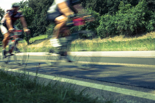 istock fast cyclists on rural street 905914556