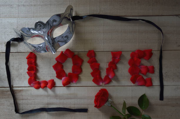 Concept With Mask Word Love Written With Rose Petals And A Red