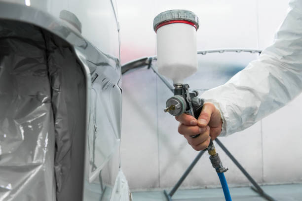 istock Painter spray gun in the hands of a painter. 905915124