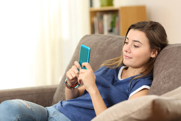istock Teenager using a blue smart phone at home 905918080