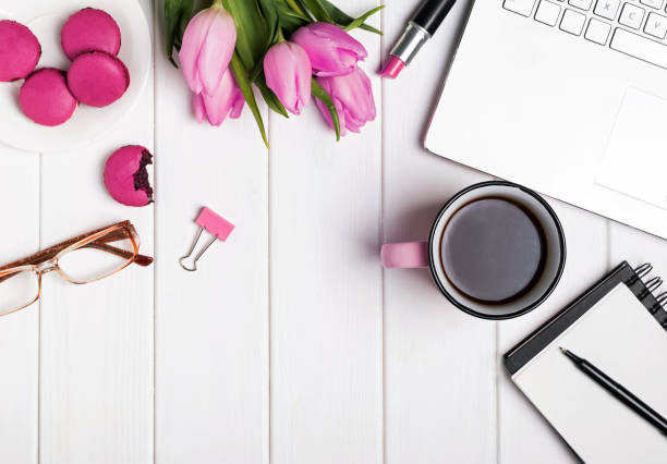 istock Womans desktop with laptop, notepad, glasses, coffee and tulips 905922182