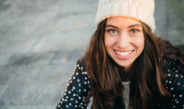happy young woman smiling on the street - coat warm clothing one person joy imagens e fotografias de stock