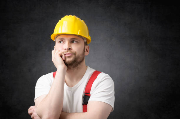 Disappointed construction worker Unhappy construction worker with yellow hard hat lazy construction laborer stock pictures, royalty-free photos & images