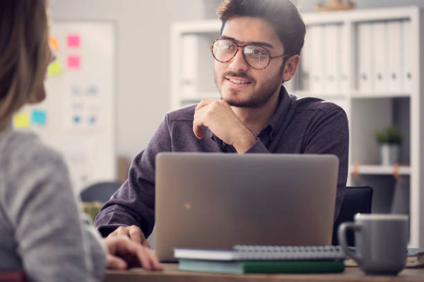 Young man listening a client in the office Young man listening a client in the office casual job interview stock pictures, royalty-free photos & images