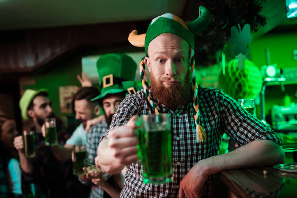 istock A man in a funny hat celebrates St. Patrick's Day with friends. 905926972