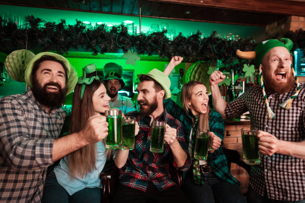 la compagnia dei giovani celebra il giorno di san patrizio. - irish culture beer drinking pub foto e immagini stock