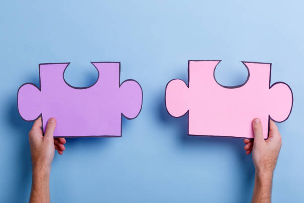istock Two puzzles that hold the hands of a man. Close-up. 905932198