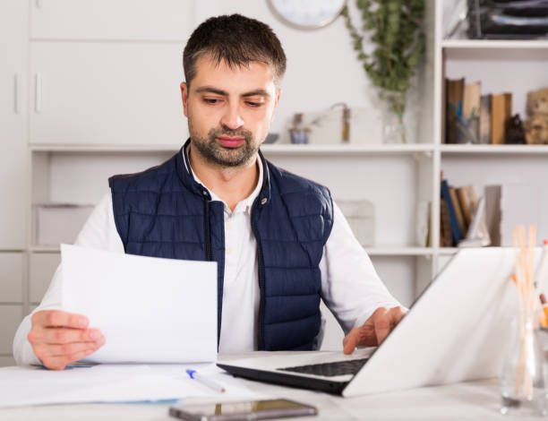 istock Businessman in shirt working with laptopt and documents 905932586