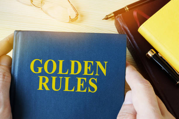 istock Man holding guide with title golden rules. 905932966